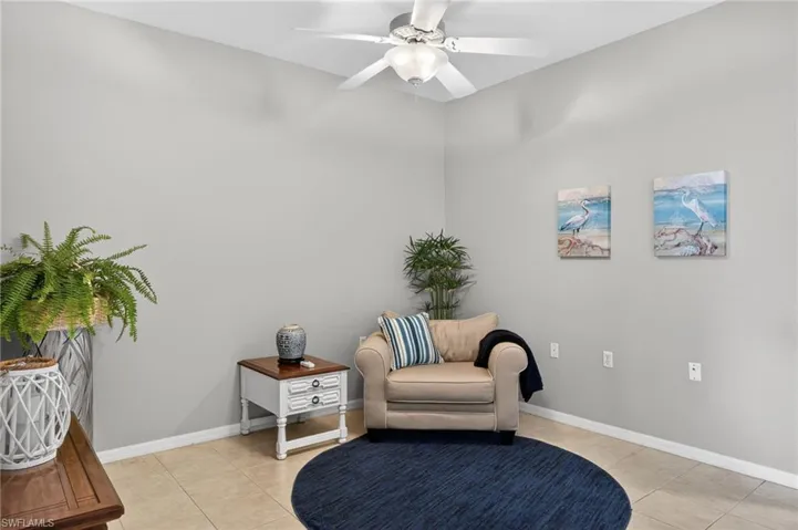 Living area with light tile patterned floors and ceiling fan