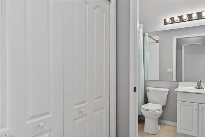 Bathroom with vanity, a shower with curtain, and light tile patterned floors