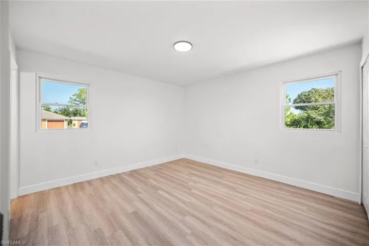 Spare room featuring light wood-type flooring and plenty of natural light
