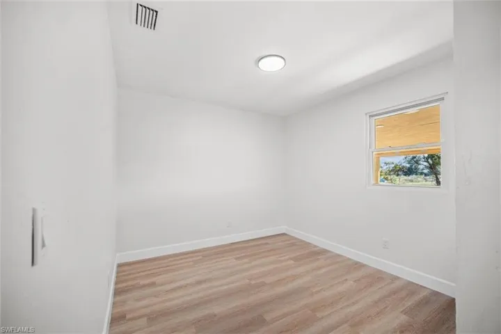 Empty room with light wood-style floors and baseboards