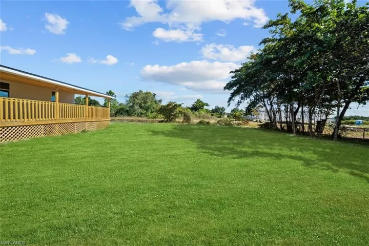 View of grassy yard with a deck