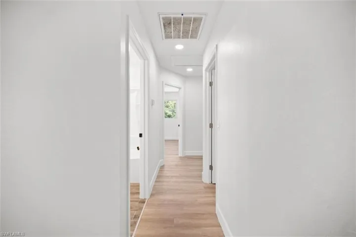 Corridor featuring light wood-style flooring and recessed lighting
