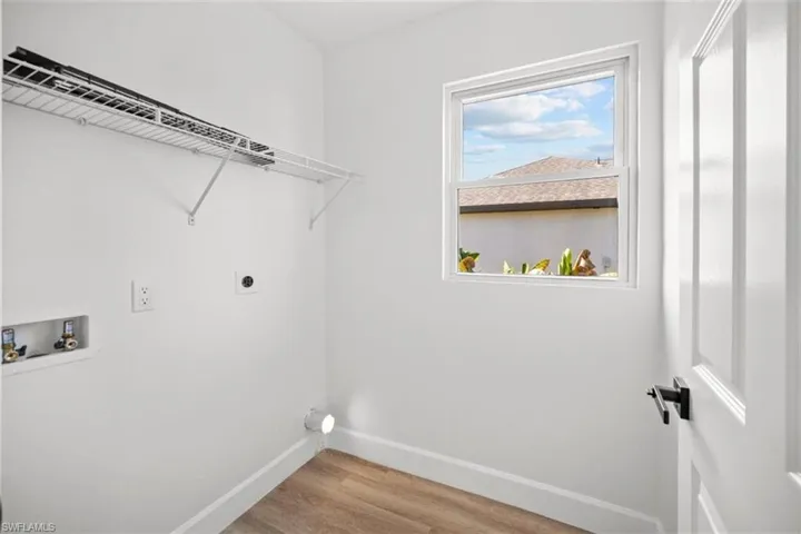 Laundry area with light wood-style floors, electric dryer hookup, and hookup for a washing machine