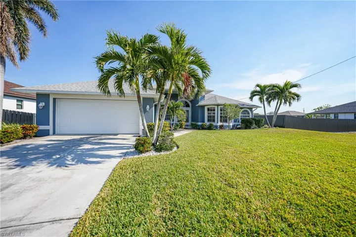 Single story home featuring a garage and a front lawn
