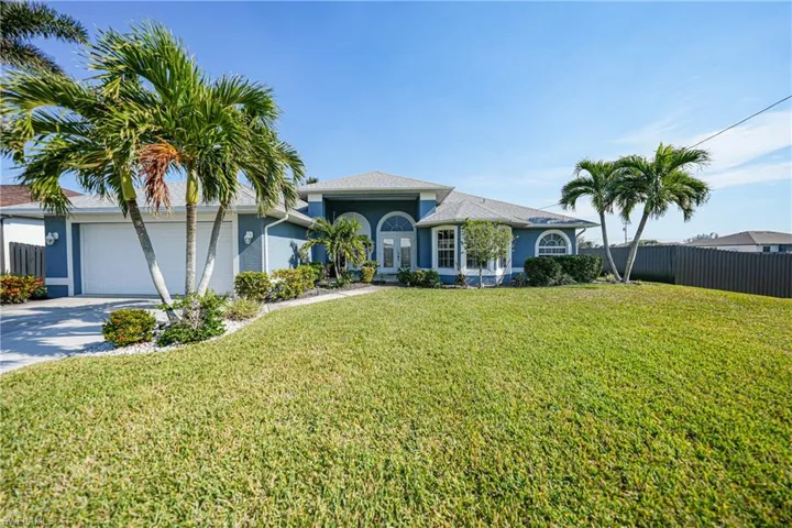 View of front of house featuring a garage and a front lawn