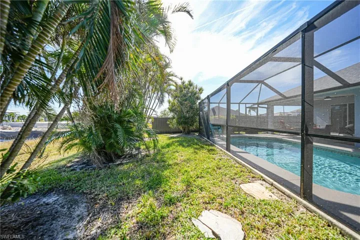 View of yard with a fenced in pool and glass enclosure