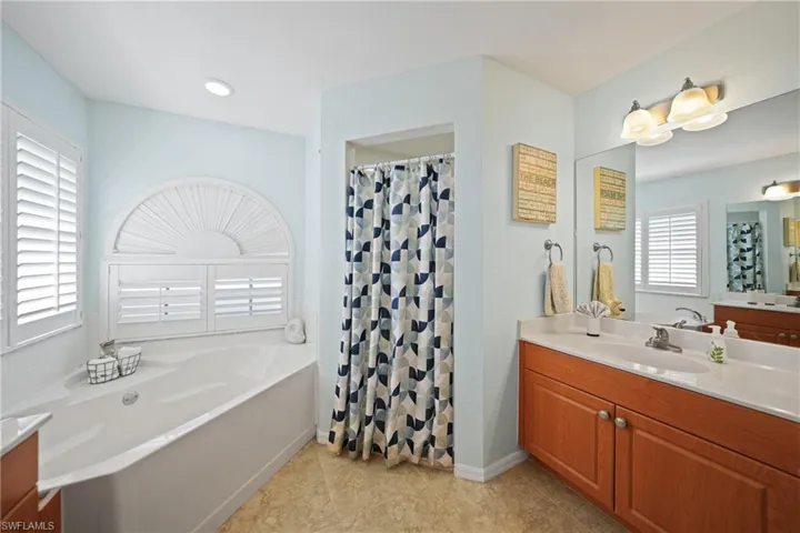 Bathroom featuring a bath, vanity, and tile patterned floors