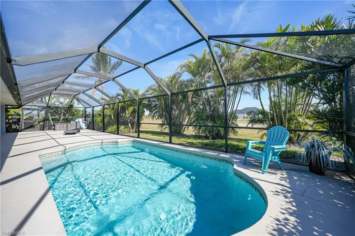 View of pool with glass enclosure and a patio area