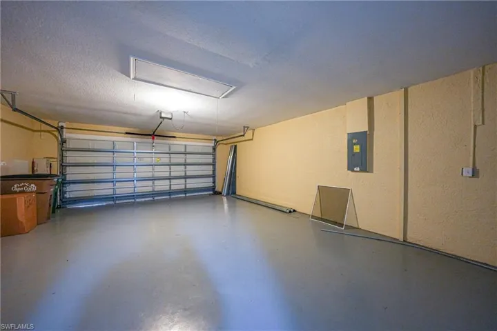 Garage featuring electric panel and a garage door opener