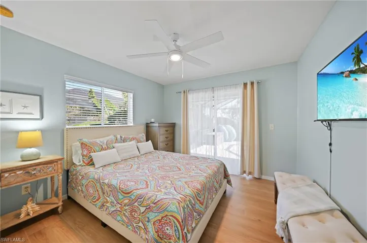 Bedroom with multiple windows, ceiling fan, and light hardwood / wood-style flooring