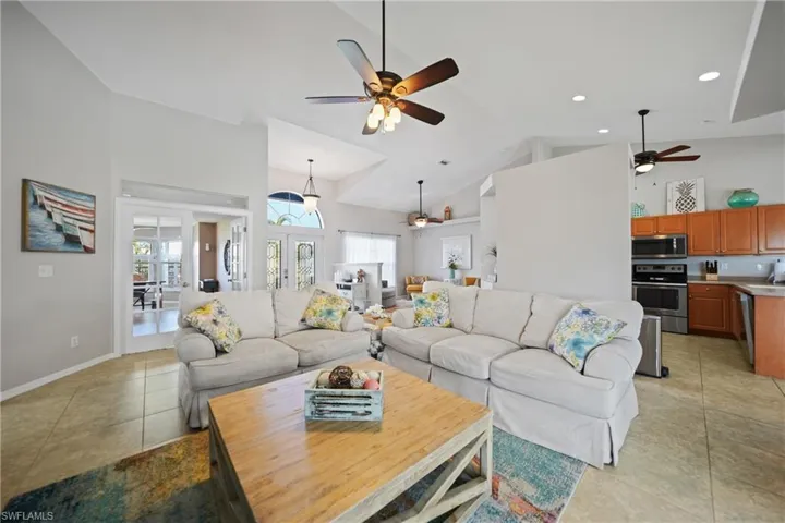 Tiled living room with high vaulted ceiling and french doors