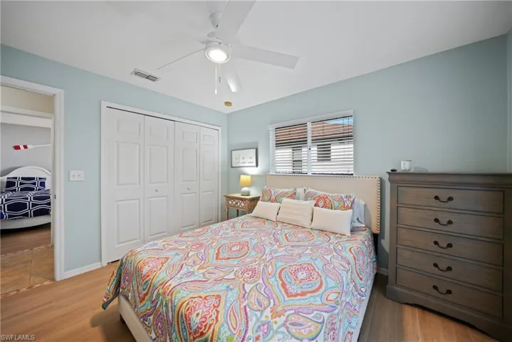 Bedroom with ceiling fan, a closet, and light hardwood / wood-style floors
