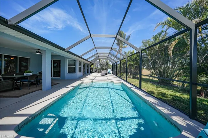 View of swimming pool with a lanai, a patio area, and ceiling fan