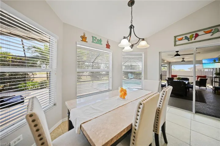 Dining area featuring light tile patterned floors, plenty of natural light, and lofted ceiling