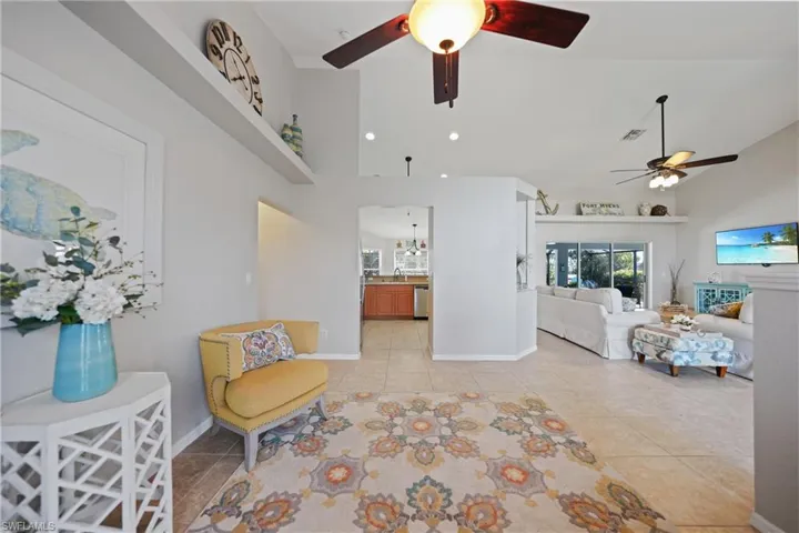 Sitting room featuring ceiling fan, sink, light tile patterned floors, and high vaulted ceiling