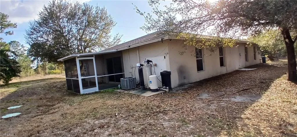 Rear view of property with a sunroom and stucco siding