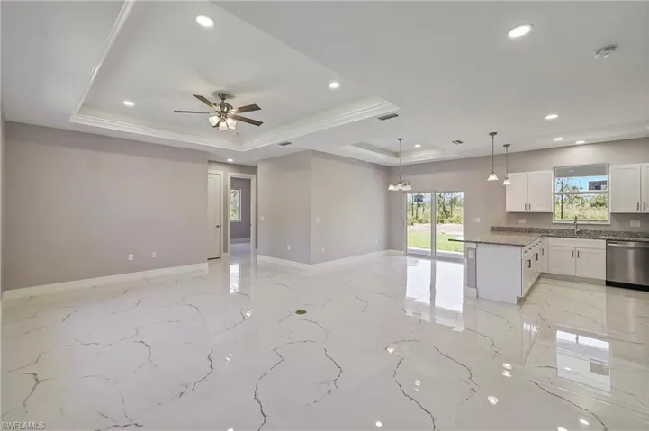 Empty room featuring a raised ceiling, recessed lighting, a ceiling fan, baseboards, and visible vents