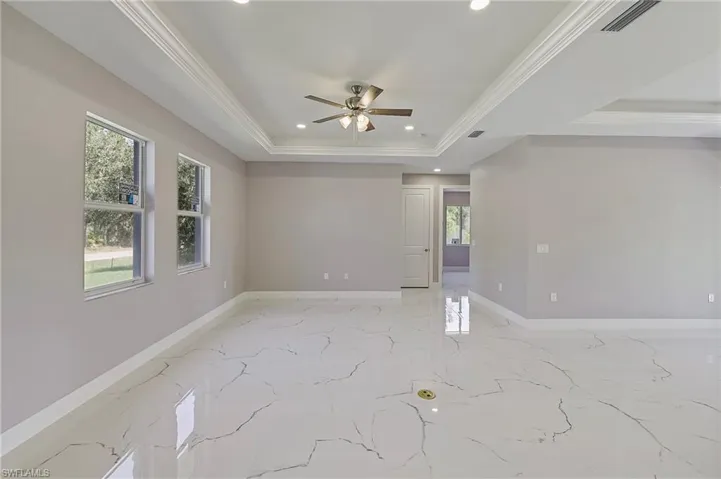 Unfurnished room featuring a tray ceiling, visible vents, and baseboards