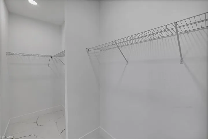 Unfurnished bedroom with baseboards, marble finish floor, and a closet