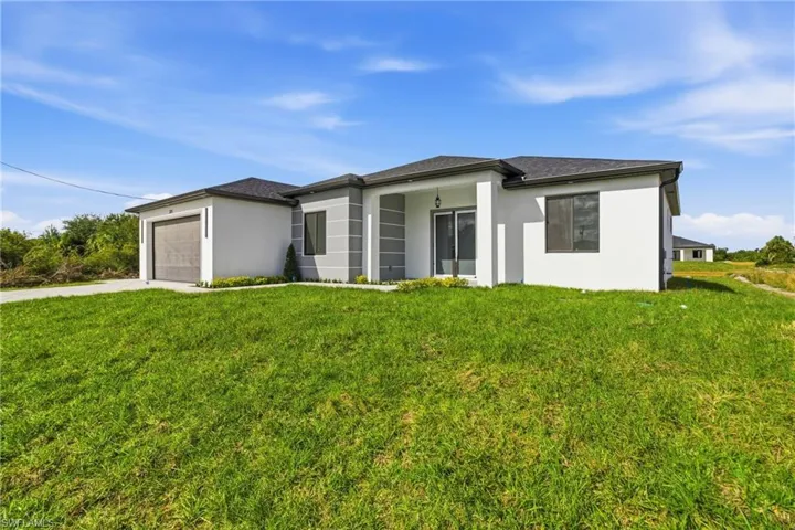 Prairie-style home featuring stucco siding, a front lawn, and a garage