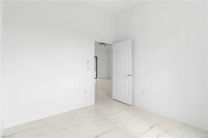 Spare room featuring light marble finish floors and ceiling fan