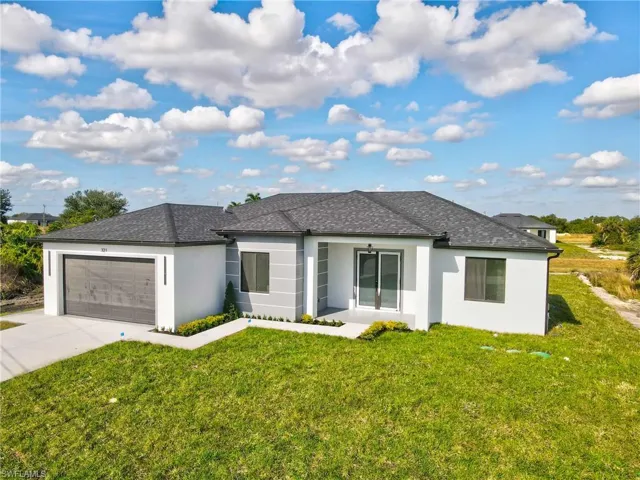 View of front of house featuring stucco siding, a front yard, and concrete driveway