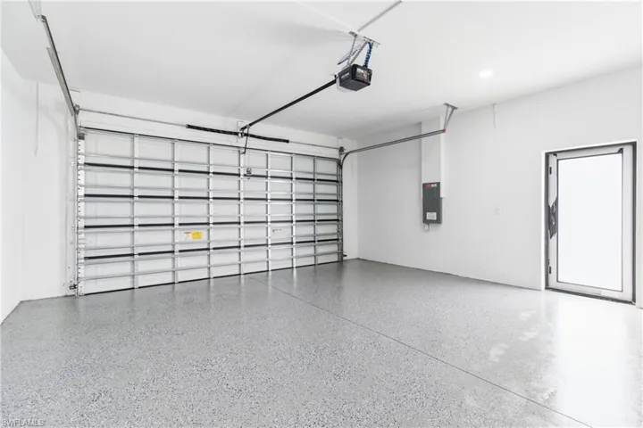 Garage featuring electric panel and a garage door opener