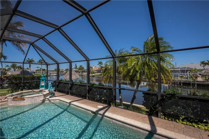 Integrated pool / spa with a residential view, a sunroom, a lanai, and a water view