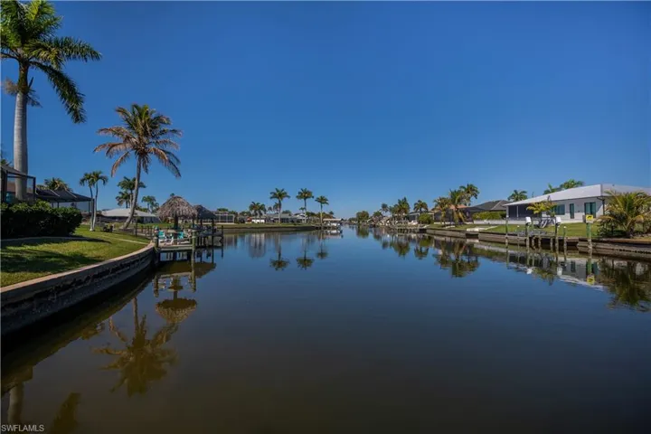 Water view featuring nearby suburban area and a boat dock