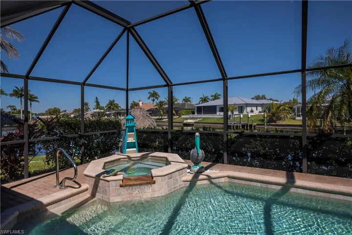 Combined pool / hot tub featuring a lanai, a sunroom, and a residential view