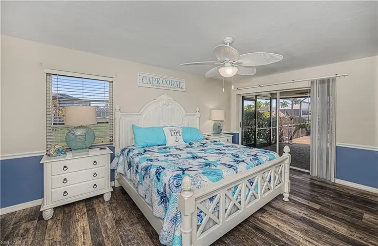 Bedroom with access to exterior, ceiling fan, and dark wood-type flooring
