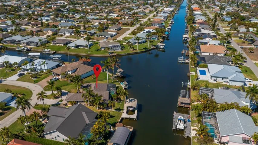 Aerial view of property's location with a nearby body of water and nearby suburban area
