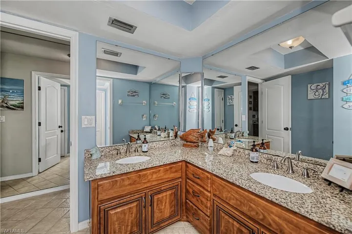 Main bathroom featuring double vanity and light tile patterned floors