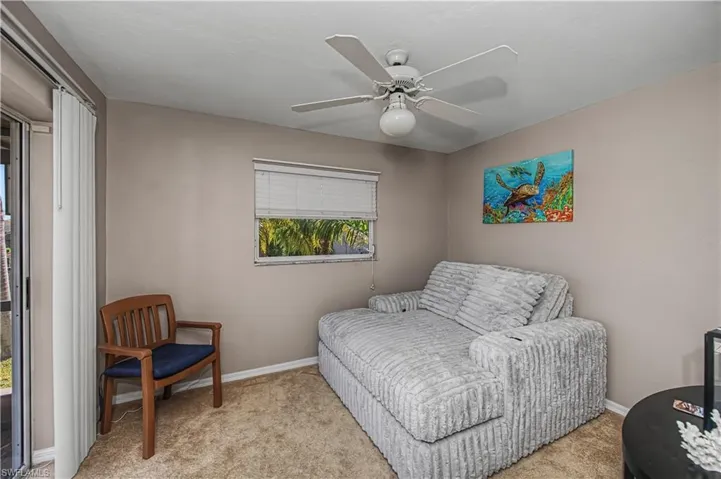 Living area featuring carpet flooring and a ceiling fan