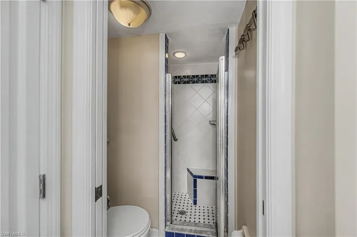 Full bathroom with a stall shower and toilet
