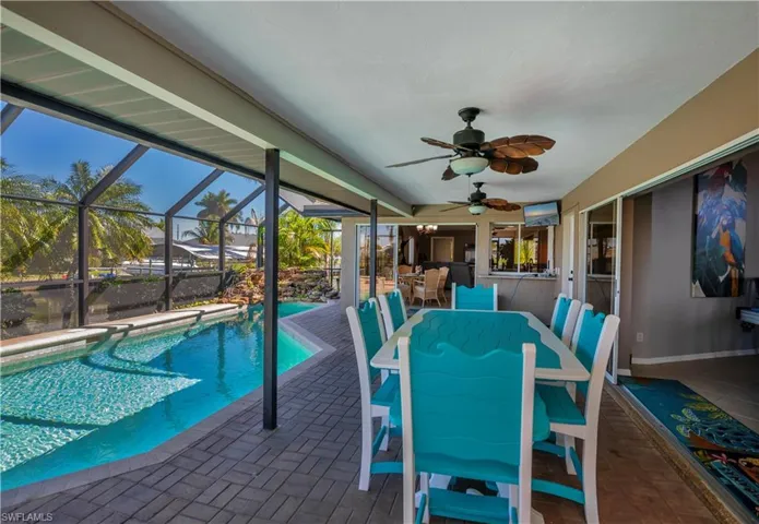 Swimming pool featuring outdoor dining space, glass enclosure, a sunroom, and a patio