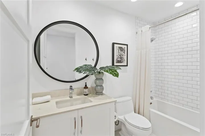 Bathroom with shower / tub combo, vanity, and recessed lighting