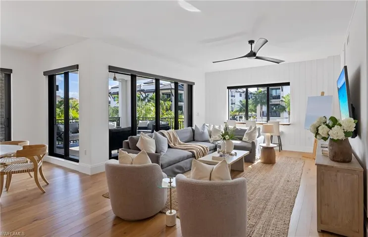 Living area with light wood-style flooring and a ceiling fan