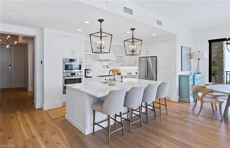 Kitchen featuring a chandelier, white cabinetry, a kitchen bar, light wood finished floors, and recessed lighting