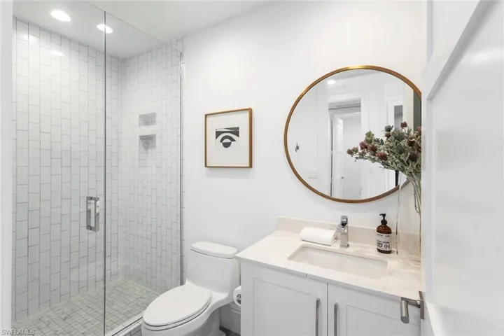 Bathroom with vanity, recessed lighting, and a stall shower