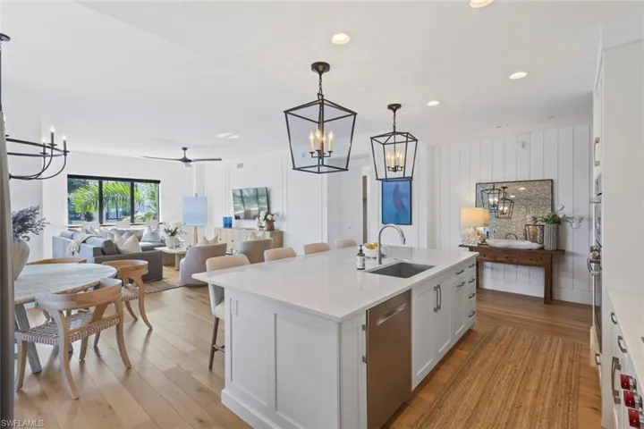 Kitchen with a chandelier, a breakfast bar area, white cabinets, pendant lighting, and open floor plan