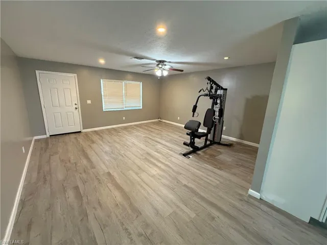 Workout area with light wood-style floors, a ceiling fan, and recessed lighting