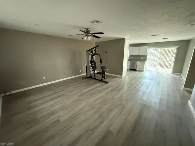 Workout area featuring light wood-style flooring and a ceiling fan