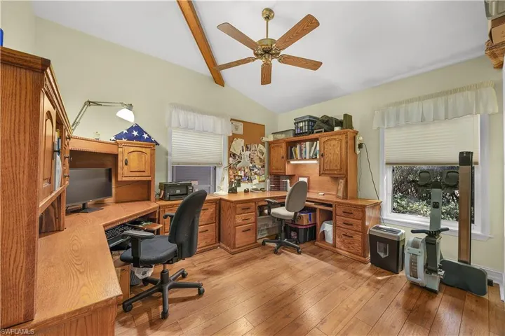 Office area with lofted ceiling with beams, light wood-style flooring, and ceiling fan