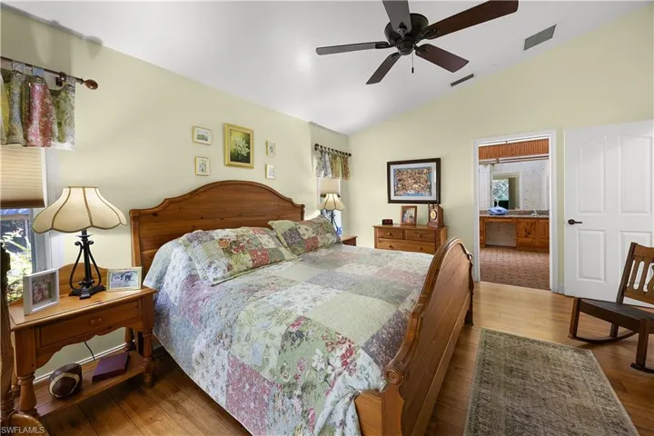Bedroom with hardwood / wood-style floors, lofted ceiling, and ceiling fan