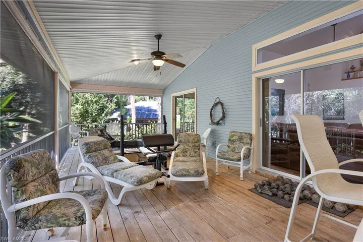 Sunroom with a ceiling fan and a deck