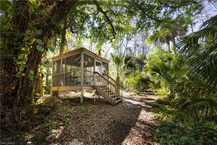 View of yard featuring a sunroom and a wooden deck