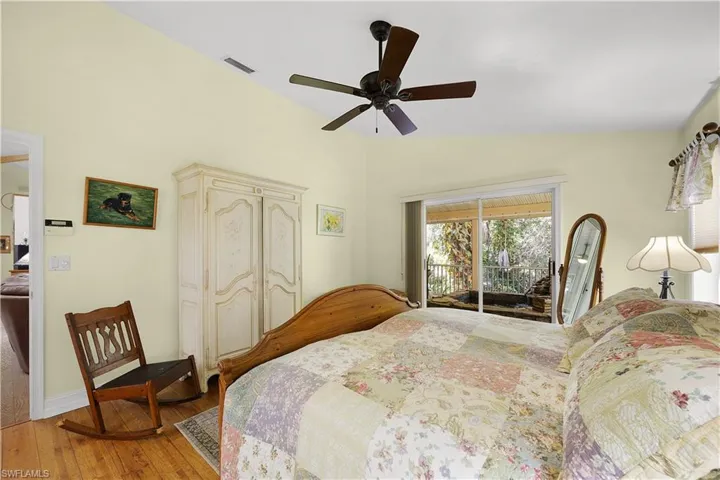 Bedroom with access to outside, hardwood / wood-style flooring, a ceiling fan, a closet, and lofted ceiling