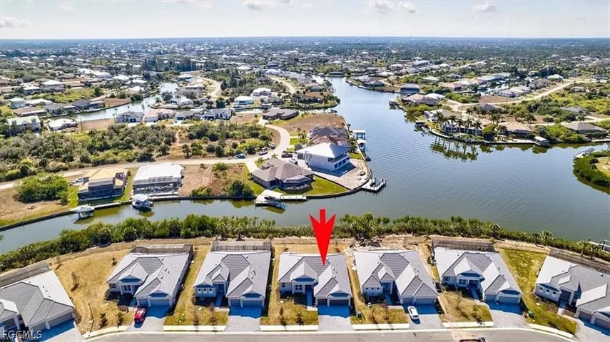 Canal-front property featuring a single-story residence with an attached garage and a concrete driveway