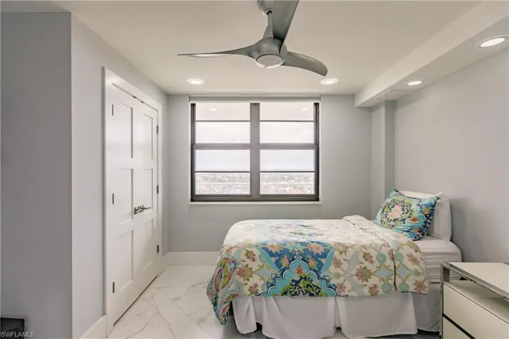 Bedroom with light marble finish floors, a ceiling fan, and recessed lighting
